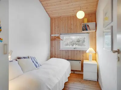a small bedroom with a bed and a window at Holiday Home Birette - 1-5km from the sea by Interhome in Blokhus