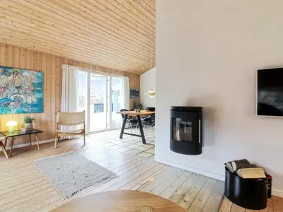 a living room with a tv on a wall at Holiday Home Birette - 1-5km from the sea by Interhome in Blokhus