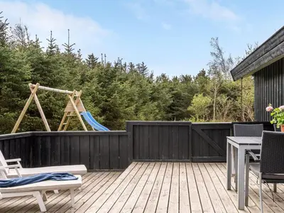 a backyard with a playground and a swing at Holiday Home Birette - 1-5km from the sea by Interhome in Blokhus