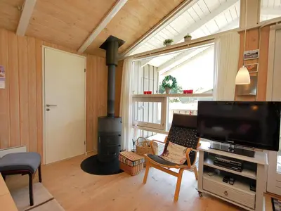 a living room with a fireplace and a flat screen tv at Holiday Home Anthonia - 1-6km from the sea by Interhome in Blokhus