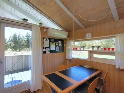 a dining room with a table and a window at Holiday Home Anthonia - 1-6km from the sea by Interhome in Blokhus