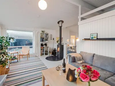 a living room with a couch and a table at Holiday Home Fenneke - 50m from the sea by Interhome in Blokhus