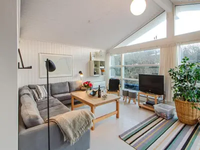 a living room with a couch and a table at Holiday Home Fenneke - 50m from the sea by Interhome in Blokhus
