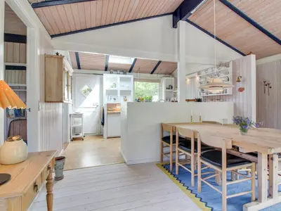a kitchen and dining room with a wooden table at Holiday Home Heike - 1-3km from the sea by Interhome in Blokhus