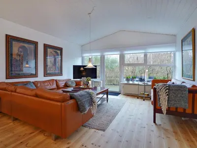 a living room with a couch and a table at Holiday Home Pelle - 800m from the sea by Interhome in Blokhus