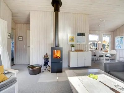 a living room with a fireplace in the middle at Holiday Home Anahi - 3km from the sea by Interhome in Blokhus