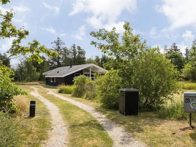 a dirt road leading to a building in a field at Holiday Home Anahi - 3km from the sea by Interhome in Blokhus