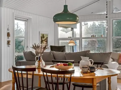 a kitchen and living room with a table and chairs at Holiday Home Onta - 900m from the sea by Interhome in Blokhus