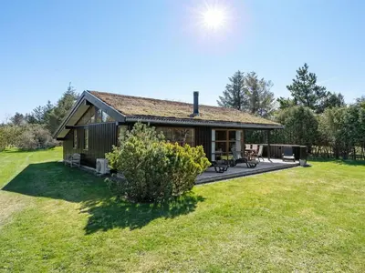 a house with a large yard with a deck at Holiday Home Jelin - 2-5km from the sea by Interhome in Blokhus