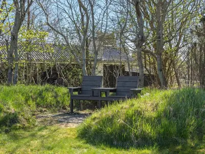 two benches sitting on top of a grassy hill at Holiday Home Jelin - 2-5km from the sea by Interhome in Blokhus