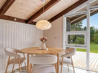 a dining room with a wooden table and chairs at Holiday Home Ingimar - 2-2km from the sea by Interhome in Blokhus