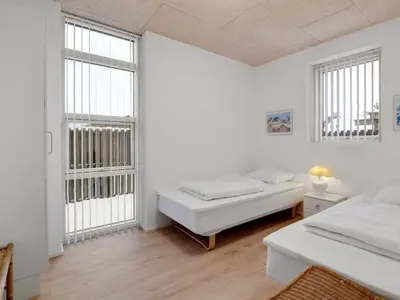 a white room with two beds and two windows at Holiday Home Klaudius - 2km from the sea by Interhome in Blokhus