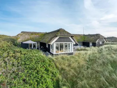 an image of a house with a grass roof at Holiday Home Henric - 100m from the sea by Interhome in Blokhus