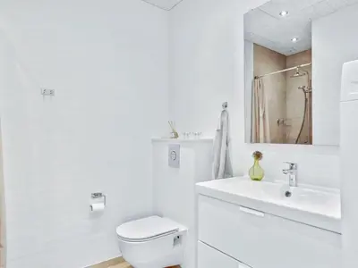 a white bathroom with a toilet and a sink at Holiday Home Ilsabe - 2km from the sea by Interhome in Blokhus