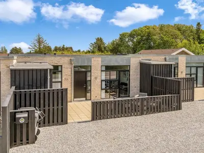 a brick house with black gates in front of it at Holiday Home Ilsabe - 2km from the sea by Interhome in Blokhus