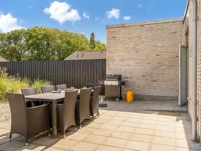 a patio with a table and chairs and a grill at Holiday Home Ilsabe - 2km from the sea by Interhome in Blokhus