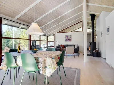 a dining room and living room with a table and chairs at Holiday Home Angja - 800m from the sea by Interhome in Blokhus