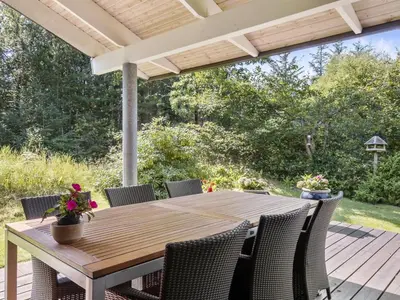 a wooden table and chairs on a deck at Holiday Home Angja - 800m from the sea by Interhome in Blokhus
