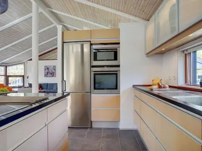 a kitchen with a stainless steel refrigerator and counters at Holiday Home Angja - 800m from the sea by Interhome in Blokhus