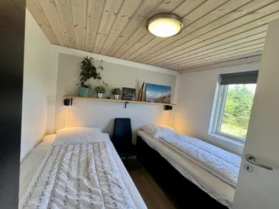 two beds in a small room with a wooden ceiling at Holiday Home Ancel - 1-7km from the sea by Interhome in Blokhus