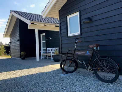 a bike parked in front of a house at Holiday Home Ancel - 1-7km from the sea by Interhome in Blokhus