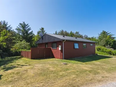 a small house with a fence in a yard at Holiday Home Lykka - 950m from the sea by Interhome in Blokhus