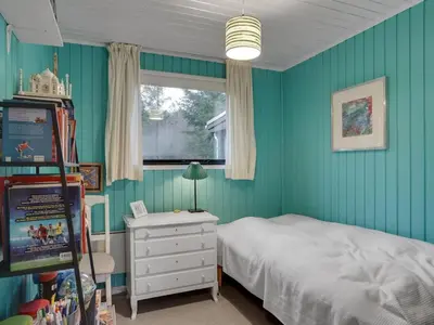 a bedroom with blue walls and a bed and a window at Holiday Home Lykka - 950m from the sea by Interhome in Blokhus