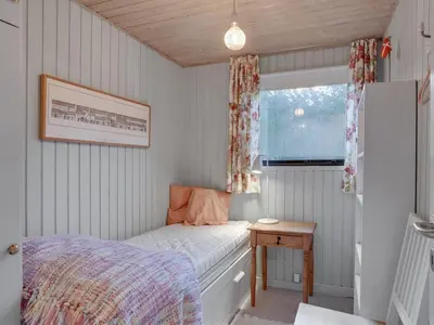a small bedroom with a bed and a window at Holiday Home Lykka - 950m from the sea by Interhome in Blokhus