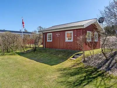 a red house with a flag on top of it at Holiday Home Amie - 800m from the sea by Interhome in Blokhus
