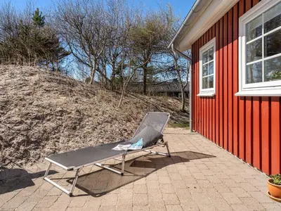 a chair sitting on a patio next to a building at Holiday Home Amie - 800m from the sea by Interhome in Blokhus