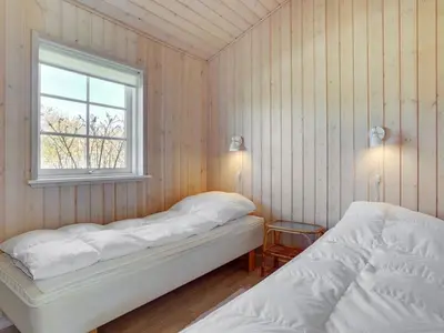 a bedroom with two beds and a window at Holiday Home Amie - 800m from the sea by Interhome in Blokhus