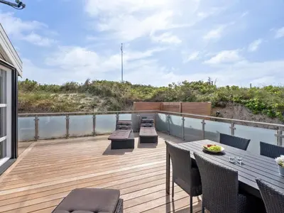 a deck with chairs and a table on a balcony at Holiday Home Swerting - 230m from the sea by Interhome in Saltum