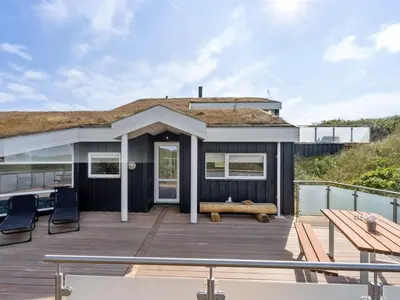 a house with a deck with a bench at Holiday Home Swerting - 230m from the sea by Interhome in Saltum