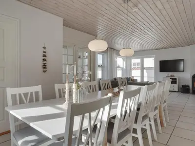 a dining room with a white table and white chairs at Holiday Home Riki - 150m from the sea by Interhome in Blokhus