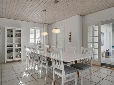 a white dining room with a white table and chairs at Holiday Home Riki - 150m from the sea by Interhome in Blokhus