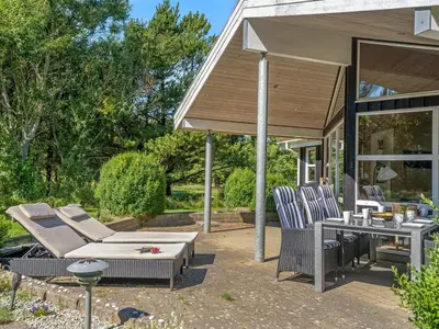 a patio with two chairs and a table and a pavilion at Holiday Home Bina - 1-9km from the sea by Interhome in Blokhus