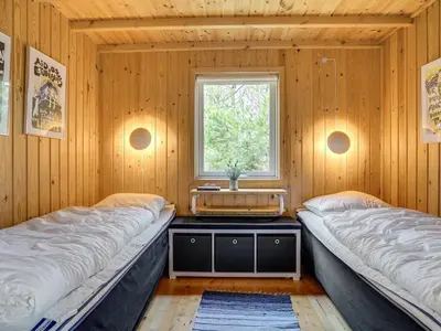 two beds in a room with a window at Holiday Home Hereth - 700m from the sea by Interhome in Saltum