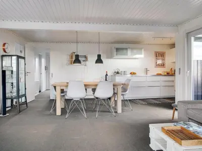 a kitchen and dining room with a table and chairs at Holiday Home Kiina - 100m from the sea by Interhome in Blokhus