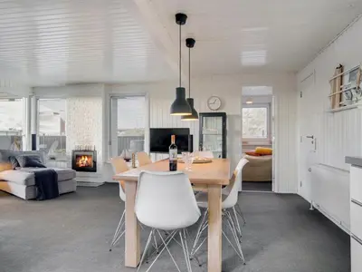 a dining room and living room with a table and chairs at Holiday Home Kiina - 100m from the sea by Interhome in Blokhus