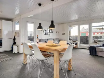 a dining room with a table and white chairs at Holiday Home Kiina - 100m from the sea by Interhome in Blokhus