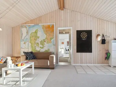 a living room with a couch and a map on the wall at Holiday Home Gerwin - 3km from the sea by Interhome in Blokhus