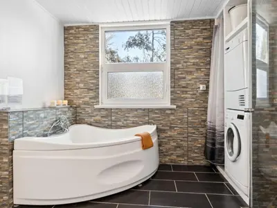 a white tub in a bathroom with a window at Holiday Home Gerwin - 3km from the sea by Interhome in Blokhus