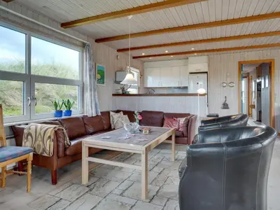 a living room with a couch and a table at Holiday Home Dana - 290m from the sea by Interhome in Saltum