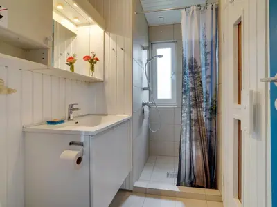 a white bathroom with a sink and a shower at Holiday Home Dana - 290m from the sea by Interhome in Saltum