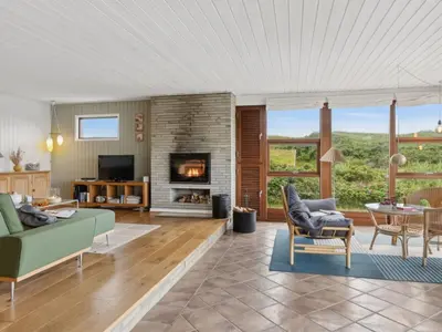 a living room with a couch and a fireplace at Holiday Home Jobst - 150m from the sea by Interhome in Saltum