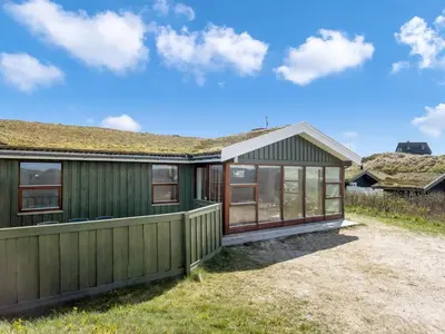 a green house with a green roof at Holiday Home Jobst - 150m from the sea by Interhome in Saltum