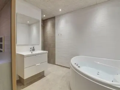 a bathroom with a white tub and a sink and a bath tub at Holiday Home Laulu - 2km from the sea by Interhome in Blokhus