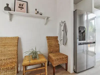 a kitchen with a table and two chairs and a refrigerator at Holiday Home Laulu - 2km from the sea by Interhome in Blokhus