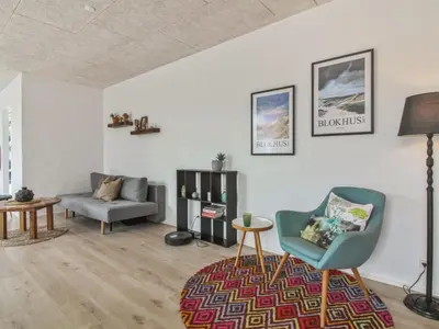 a living room with a couch and a chair at Holiday Home Laulu - 2km from the sea by Interhome in Blokhus