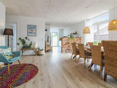 a dining room and living room with a table and chairs at Holiday Home Laulu - 2km from the sea by Interhome in Blokhus